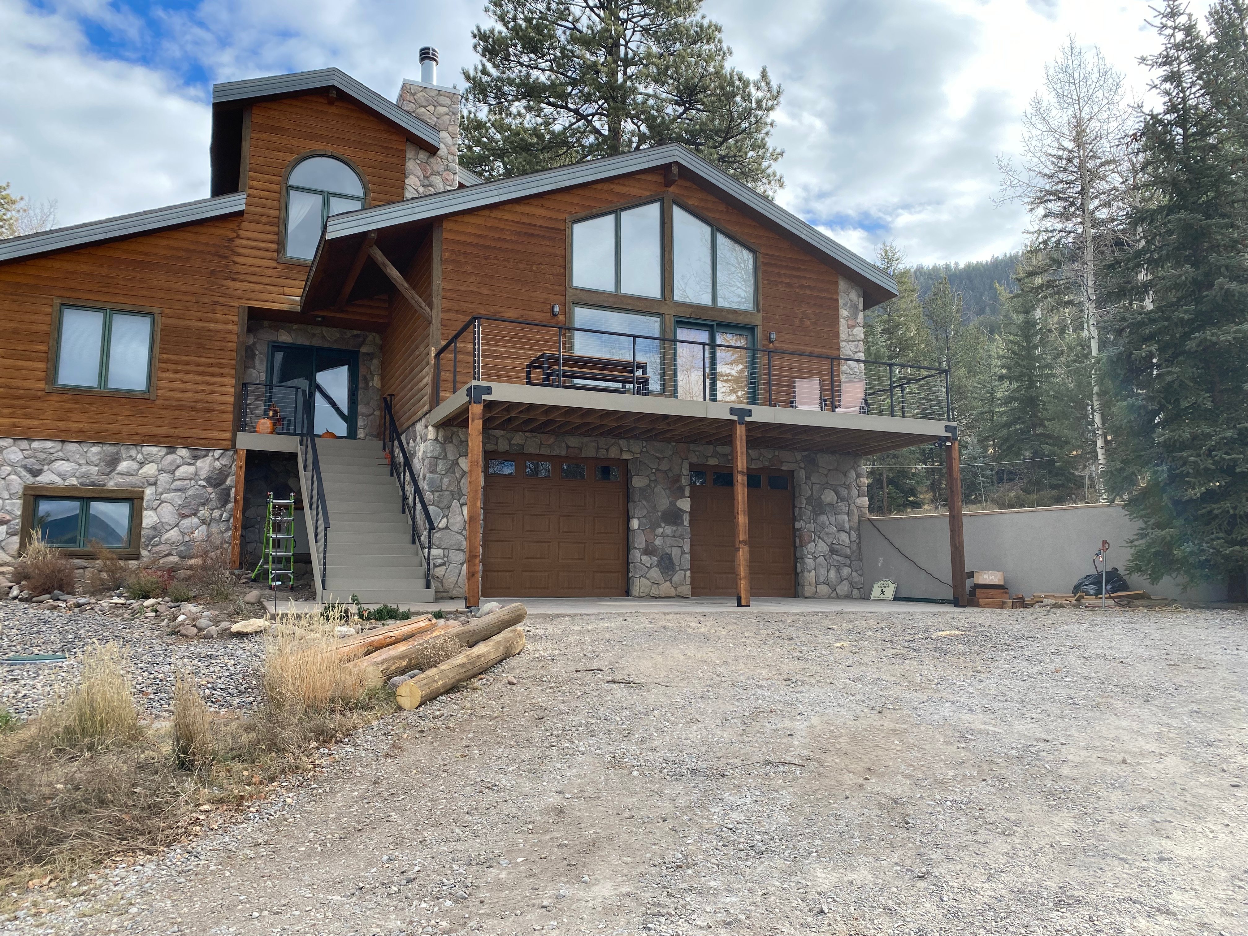 Log home with new composite balcony and black steel railing in the Colorado mountains